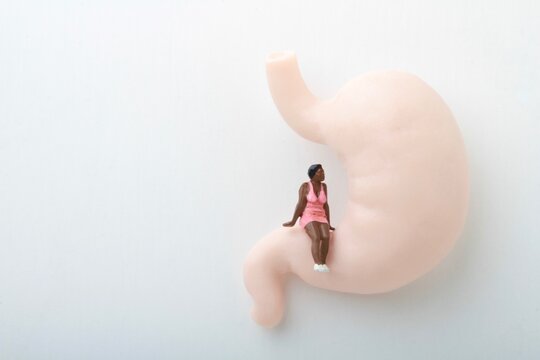 miniature figurine of a black woman sitting on a huge human stomach
