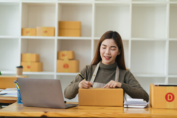 Starting Small business entrepreneur SME freelance,Portrait young woman working at home office, BOX,smartphone,laptop, online, marketing, packaging, delivery, SME, e-commerce concept