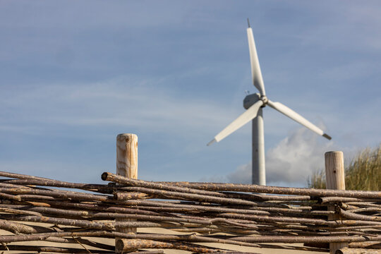 A large fan appears behind a wooden fence