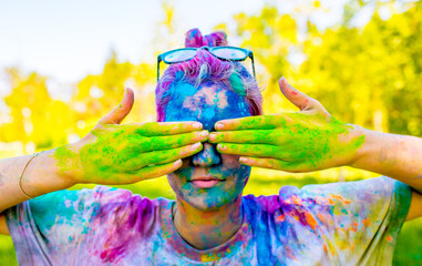 Holi is a festival of colored paints made from powder and dust. Hands with paint. People covered in...