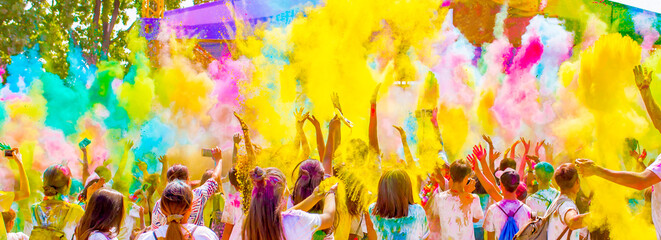 Holi Colorful festival of colored paints of powders and dust. People covered with colored powder rejoice celebrate and dance. Holiday bright colors for the entertainment of people. - obrazy, fototapety, plakaty