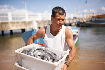 Catching fish for a living. Cropped shot of a fisherman carrying the fish he caught.