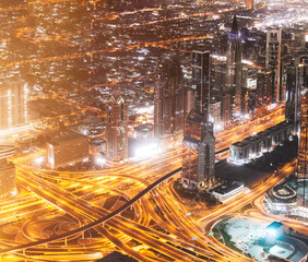 Fototapeta na wymiar Aerial View Of Urban Cityscape Skyline At Night. City Background Of Illuminated Cityscape With Skyscrapers And Modern Urban Architecture In Dubai. Street Night Traffic With Illuminations. High quality