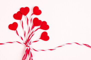 Red heart with rope on pink background.
