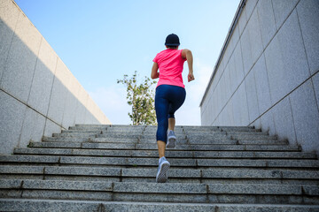 Fitness sports woman running up stairs in city