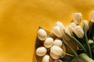 tulips and eggs on a yellow background, the concept of Easter 