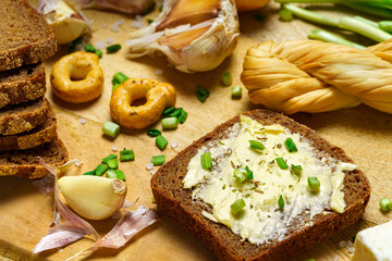 tasty lunch in rural style, healthy food - bread and butter sandwich, feta cheese, eggs, green leek and rye bread, cooked food on a white wooden boards