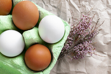 Easter layout. White and brown eggs in a green box. There are flowers nearby. Serving the Easter table. Postcard.