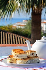 Sultana scones stacked on a plate with views towards the Mediterranean Sea, Calahonda, Spain.