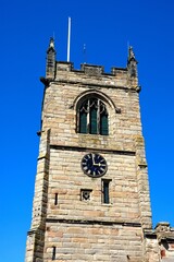 View of All Saints Church clock tower along Church Lane, Kings Bromley, Staffordshire, UK.