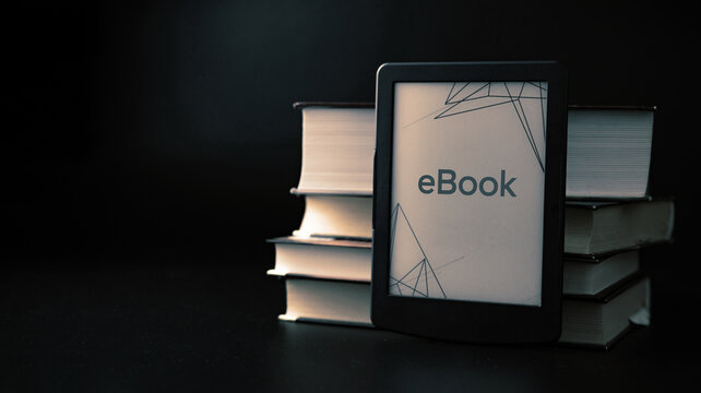 E reader. Digital e book, library reader tablet with books on dark background. Online education course, E learning class and ebook digital technology concept.