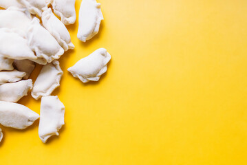 traditional Russian frozen dumplings pelmeni over yellow background