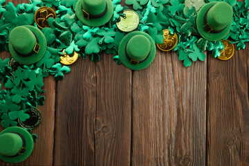 St Patricks Day border of shamrocks and coins over a rustic wood background