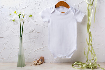 White baby short sleeve bodysuit mockup with lily and green ribbon