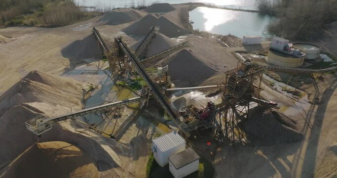 Aerial shot of machines and trucks working in a sand quarry, in France. Those are extracting and  filtering the sand.