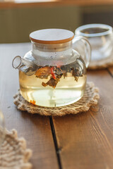 transparent glass teapot pour black tea. glows in the sun the last rays
