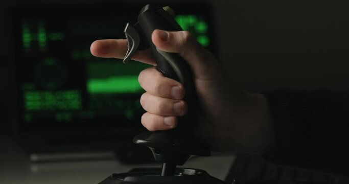 Hand of a military pilot controls a remote spy surveillance drone for warfare