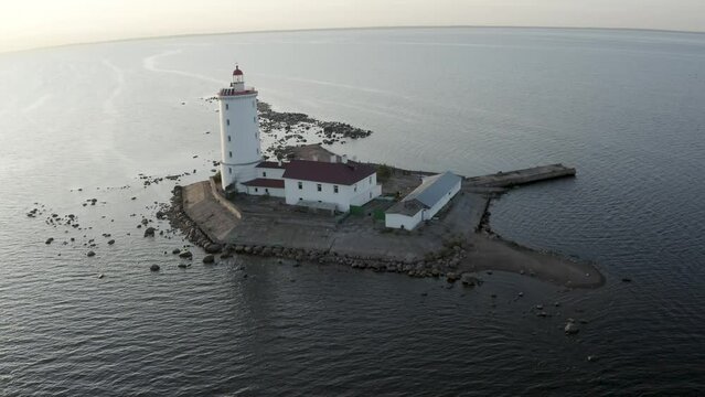 Panoramic aerial view of the Tolbukhin lighthouse. Artificial rocky island in the Gulf of Finland. The oldest Russian lighthouse. Baltic Sea. Stony coast. Summer day. Blue sk