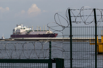 PROTECTING SITE - Separating seaport with fence and razor wire 
