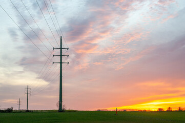 The setting sun in the flemish country side colors the sky intensely yellow and orange.