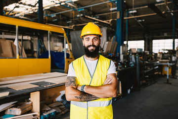 A workshop worker posing with arms crossed.