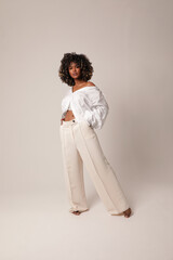 Full-length of beautiful young black woman posing in the white studio. Isolated.