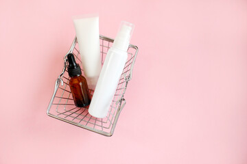 Shopping trolley full cosmetic goods on pink background. Black friday concept. Sale and discount....