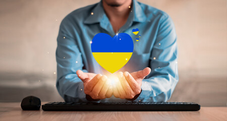 Hand holding Ukraine flag in the shape of heart. Russian-Ukrainian conflict. National security society, prevention of war in Ukrain