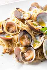 Piatto di deliziosi spaghetti con vongole veraci, olio, aglio e prezzemolo, tipica ricetta di pasta Italiana 