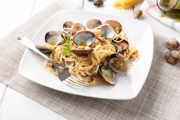 Piatto di deliziosi spaghetti con vongole veraci, olio, aglio e prezzemolo, tipica ricetta di pasta...