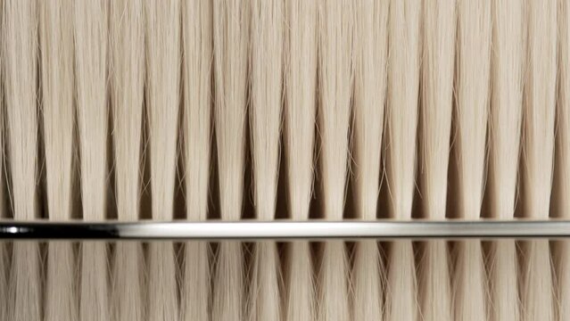 A silver comb combing blonde hair | Natural hair care concept