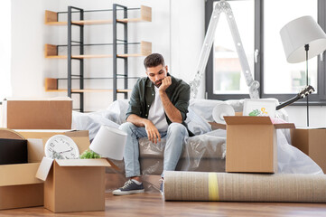 moving, eviction and real estate concept - sad man with boxes at new home