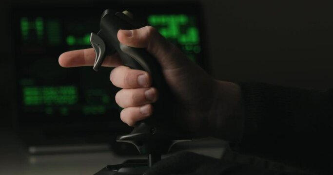 Hand of a military pilot controls a remote spy surveillance drone for warfare