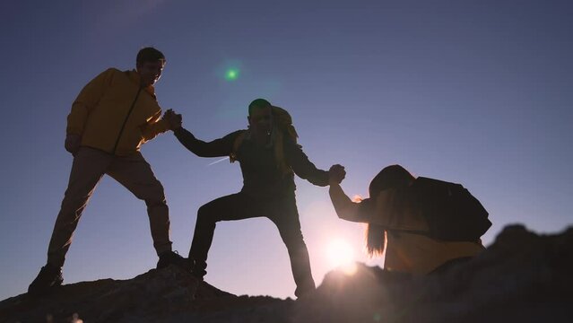 Family team success.Silhouette of group people.Climb to the top of mountain.Helping hand family victory.Teamwork concept.Business handshake.Helping hand of business people.Teamwork is path to success