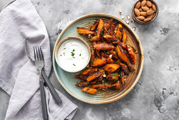 Honey garlic butter roasted carrots on a concrete background. Roasted carrots prepared with garlic butter and sweet honey sauce. Homemade glazed carrots