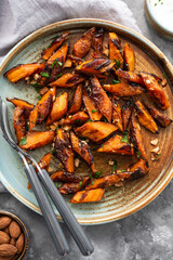 Honey garlic butter roasted carrots on a concrete background. Roasted carrots prepared with garlic butter and sweet honey sauce. Homemade glazed carrots