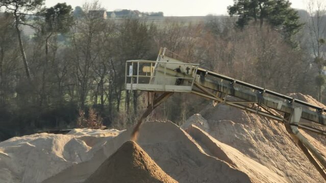 Aerial shot of machines and trucks working in a sand quarry, in France. Those are extracting and  filtering the sand.