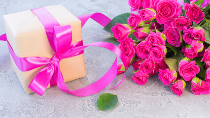 Bouquet of pink roses and a box with a gift