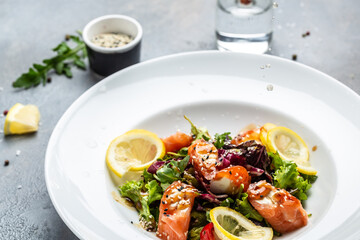 Salmon fish salad. Fresh vegetable lettuce and salmon fish fillet, healthy food, omega 3, keto diet, mediterranean cusine top view