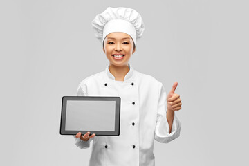 cooking, culinary and people concept - happy smiling female chef with tablet pc computer showing thumbs up over grey background