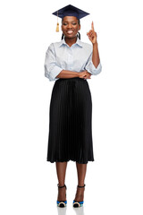 education, graduation and people concept - happy graduate student woman or bachelor in mortarboard pointing finger up over white background