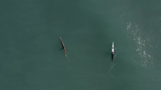 Single seat canoe rowing over a shallow lagoon, Aerial view.