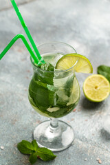 Mojito cocktail with lime and mint in highball glass on gray background vertical image. place for text