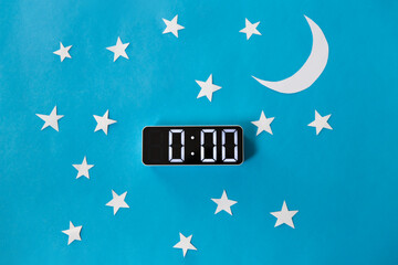 bedtime, sleeping and night time concept - close up of electronic alarm clock showing midnight hour...