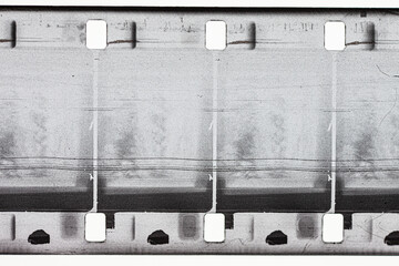 16 mm film, grey with sprocket holes, scratches and blurred exposure.