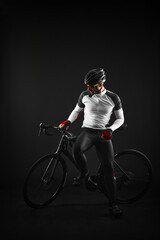 Fototapeta premium male cyclist with road bicycle on black background
