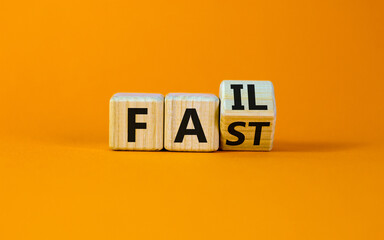 Fail fast symbol. Turned a wooden cube with concept words Fail fast on beautiful orange table...