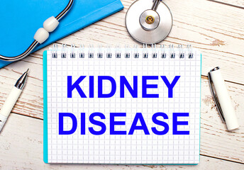 On a background there is a stethoscope, a notebook, a pen and a sheet of paper with the text KIDNEY DISEASE