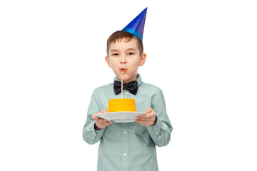 birthday, childhood and people concept - portrait of smiling little boy in party hat blowing to candle on cake over white background
