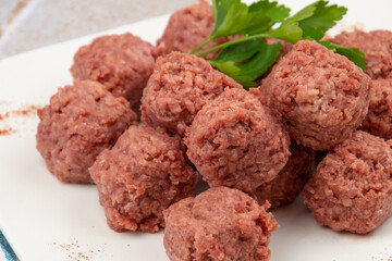 close up of raw beef dumpling in white plate